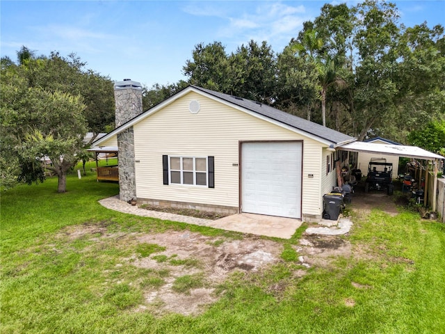 rear view of property with a garage and a yard