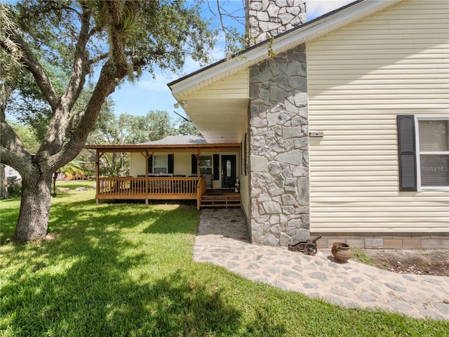 view of property exterior featuring a wooden deck and a lawn