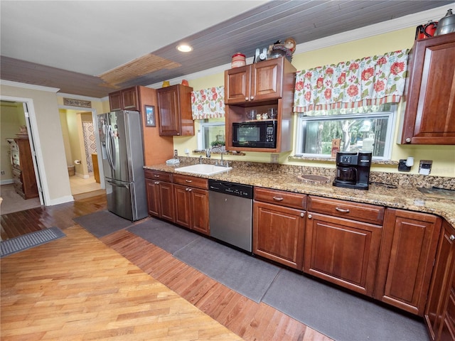 kitchen with sink, light stone countertops, stainless steel appliances, and light hardwood / wood-style floors