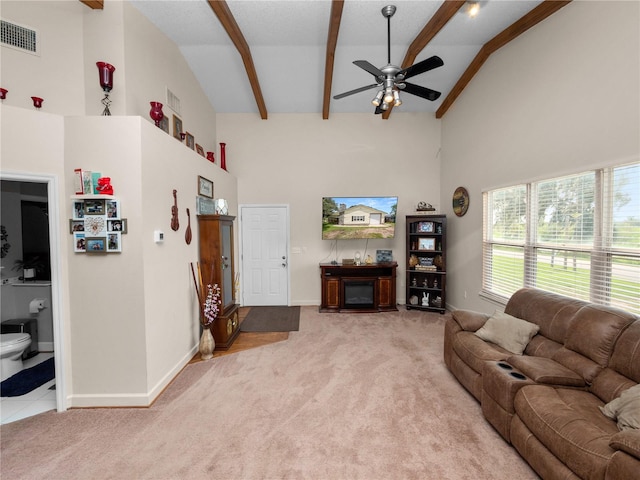 living room with beam ceiling, light carpet, and ceiling fan