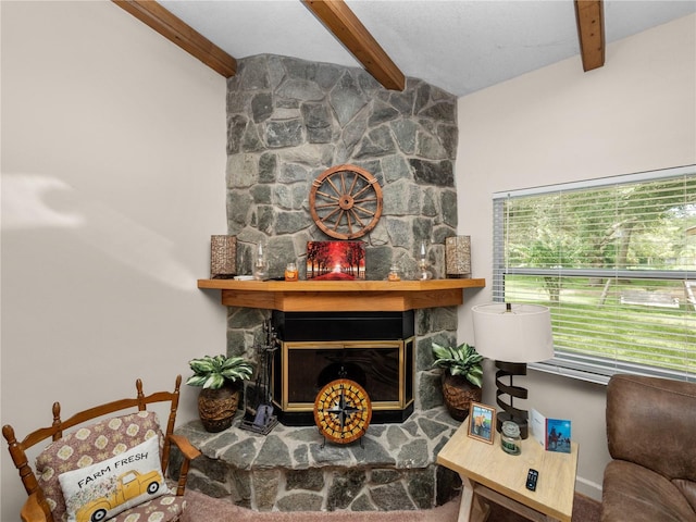 living room featuring a stone fireplace and beamed ceiling