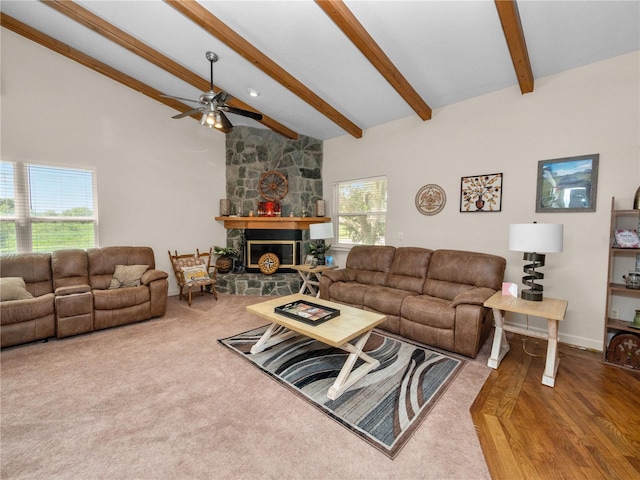 living room featuring ceiling fan, a stone fireplace, hardwood / wood-style flooring, and a healthy amount of sunlight