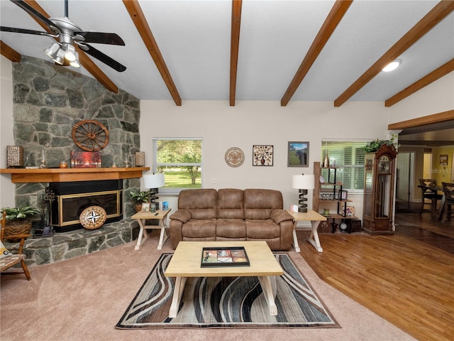 living room featuring a fireplace, wood-type flooring, ceiling fan, and vaulted ceiling with beams