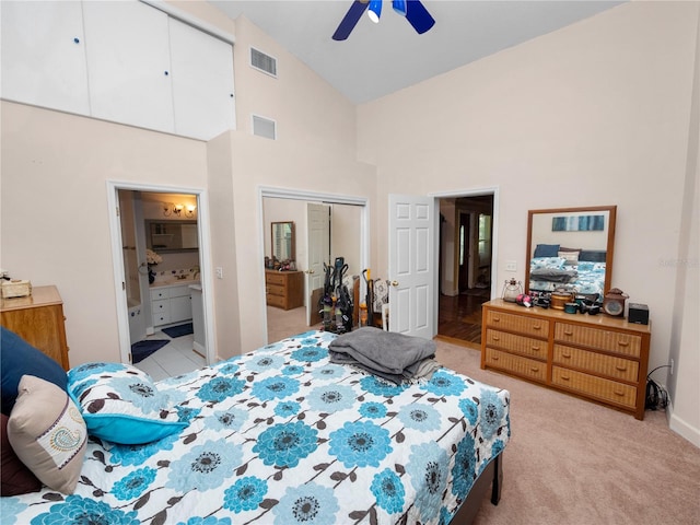 bedroom featuring light tile patterned flooring, a closet, ceiling fan, high vaulted ceiling, and ensuite bathroom