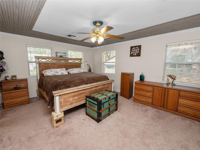 carpeted bedroom with multiple windows, ornamental molding, and ceiling fan