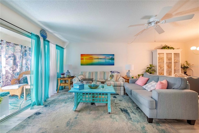 living room featuring ceiling fan, hardwood / wood-style floors, and a textured ceiling