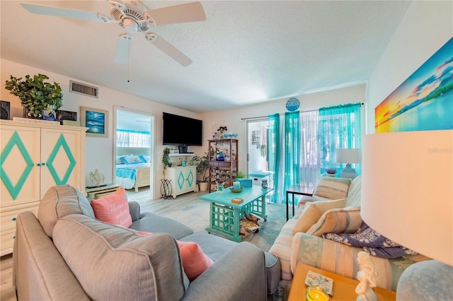 living room with a textured ceiling and light hardwood / wood-style floors