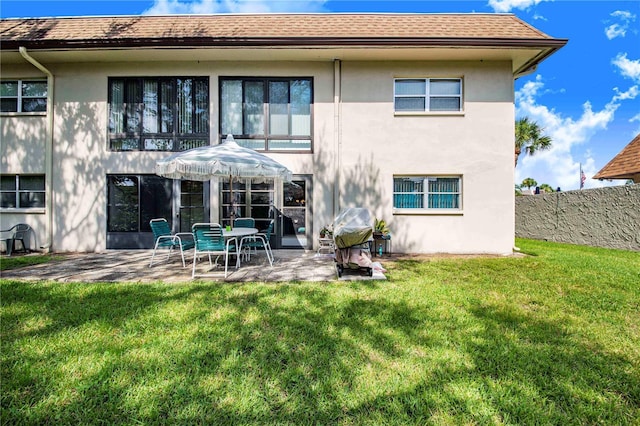 rear view of house featuring a yard and a patio