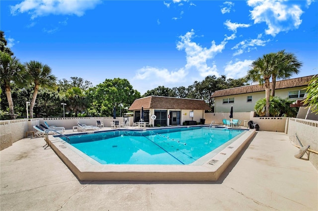 view of swimming pool with an outbuilding and a patio