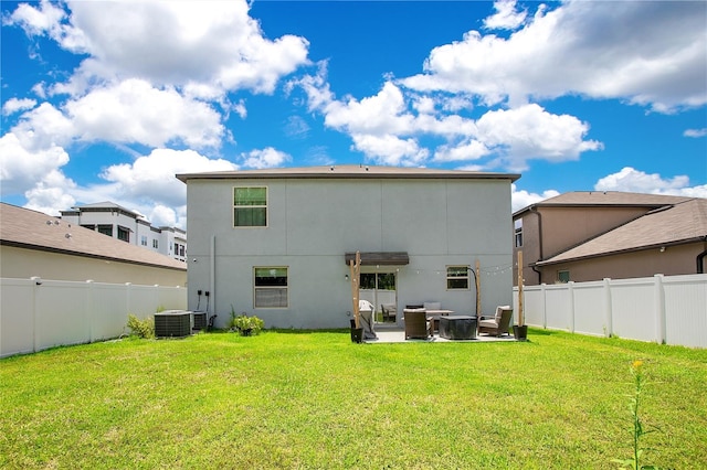 back of property with central AC, a patio, and a yard