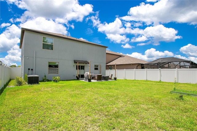 rear view of house with central AC, a lawn, a lanai, and a patio area