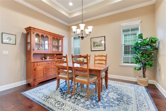 dining room with a raised ceiling, ornamental molding, dark hardwood / wood-style floors, and a notable chandelier