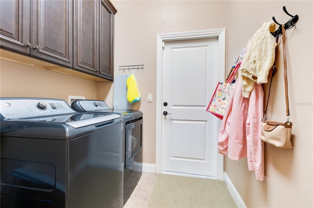 clothes washing area featuring cabinets and washing machine and dryer