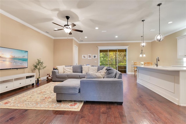 living room with ceiling fan, crown molding, dark wood-type flooring, and sink