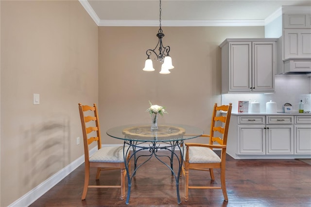 dining area featuring dark hardwood / wood-style floors, crown molding, and an inviting chandelier