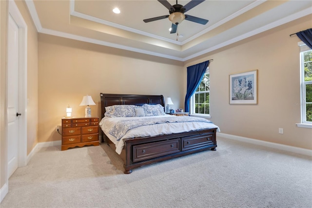 bedroom with ornamental molding, a tray ceiling, ceiling fan, and light colored carpet