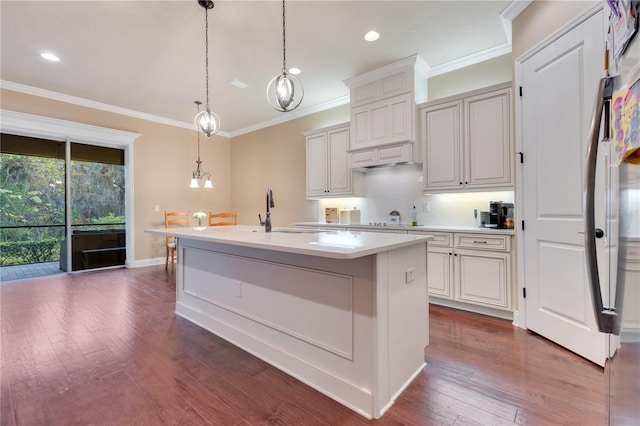 kitchen featuring dark hardwood / wood-style flooring, a kitchen island with sink, sink, white cabinetry, and hanging light fixtures