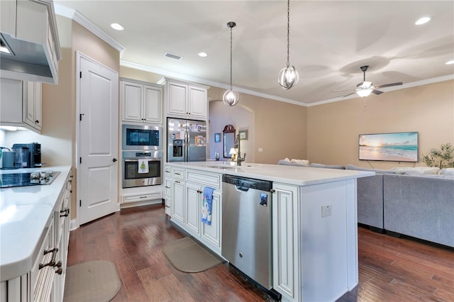 kitchen with ceiling fan, pendant lighting, built in appliances, white cabinets, and a center island