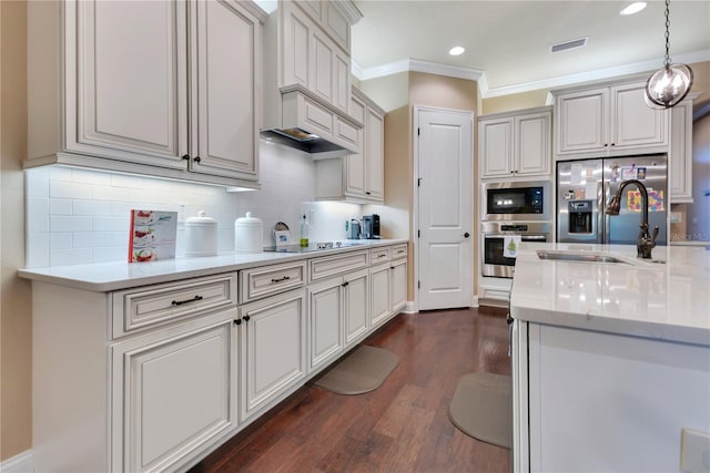 kitchen featuring dark hardwood / wood-style flooring, stainless steel appliances, crown molding, sink, and hanging light fixtures