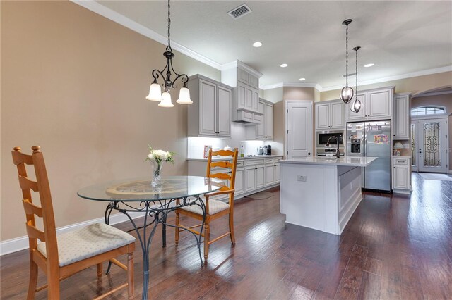 kitchen with stainless steel appliances, a kitchen island with sink, crown molding, pendant lighting, and gray cabinets