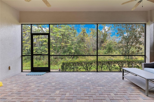 unfurnished sunroom featuring ceiling fan