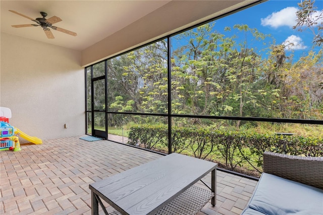 sunroom / solarium featuring ceiling fan