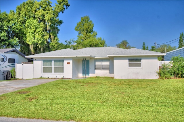 ranch-style house with driveway, a front yard, fence, and a gate