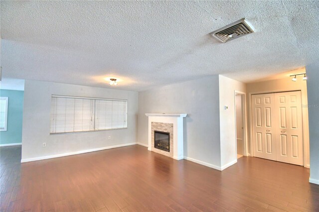 unfurnished living room featuring a textured ceiling and wood-type flooring