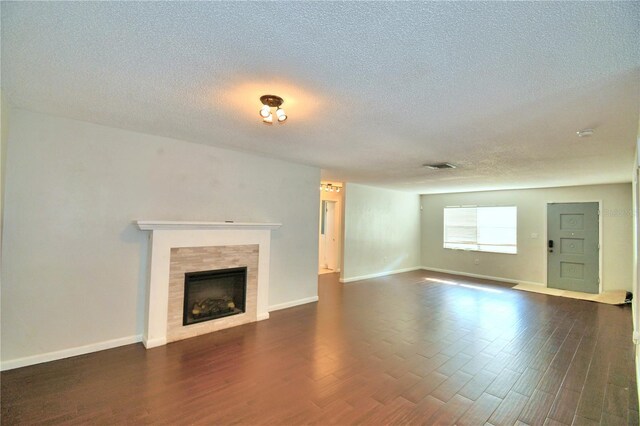 unfurnished living room featuring a textured ceiling, a fireplace, and wood-type flooring