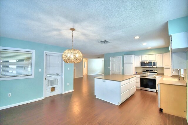 kitchen with pendant lighting, sink, white cabinets, dark wood-type flooring, and range with electric cooktop