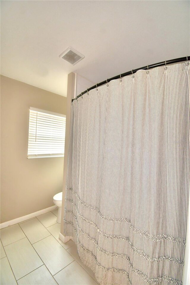 bathroom with tile patterned floors and toilet