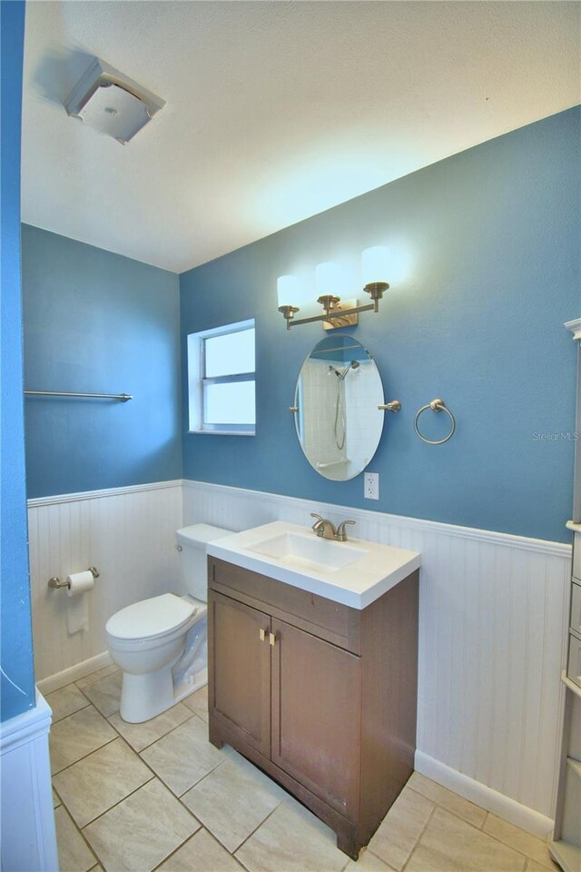 bathroom featuring vanity, toilet, and tile patterned flooring