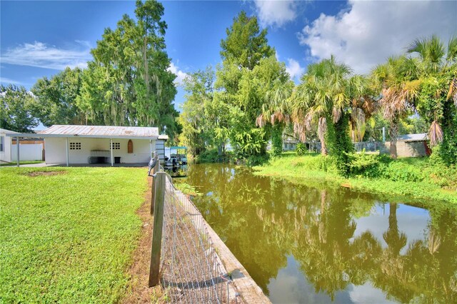 dock area with a water view and a lawn