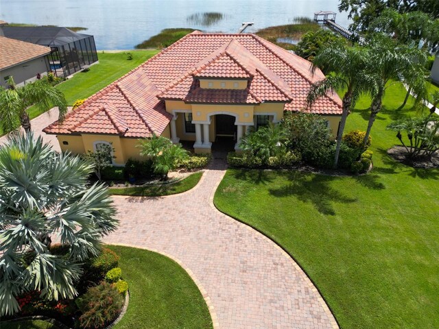 mediterranean / spanish home with a water view and a front lawn