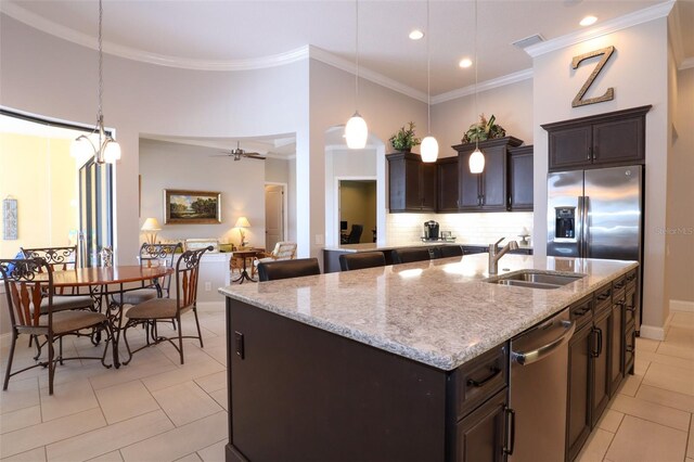 kitchen featuring light stone countertops, appliances with stainless steel finishes, a kitchen island with sink, sink, and ceiling fan