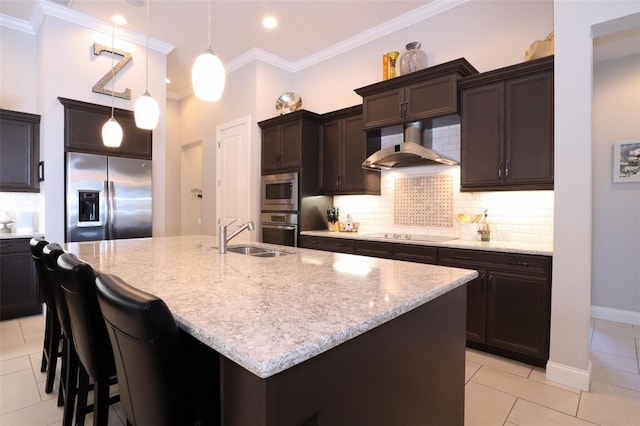 kitchen with an island with sink, wall chimney exhaust hood, stainless steel appliances, and a sink