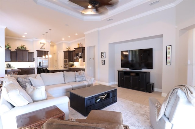 living room with crown molding, ceiling fan, light tile patterned floors, and a tray ceiling