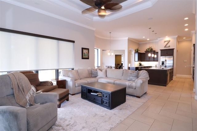 living area with light tile patterned floors, a ceiling fan, ornamental molding, a tray ceiling, and recessed lighting