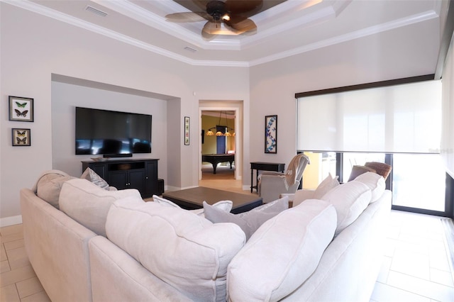 tiled living room with ceiling fan, a raised ceiling, and crown molding