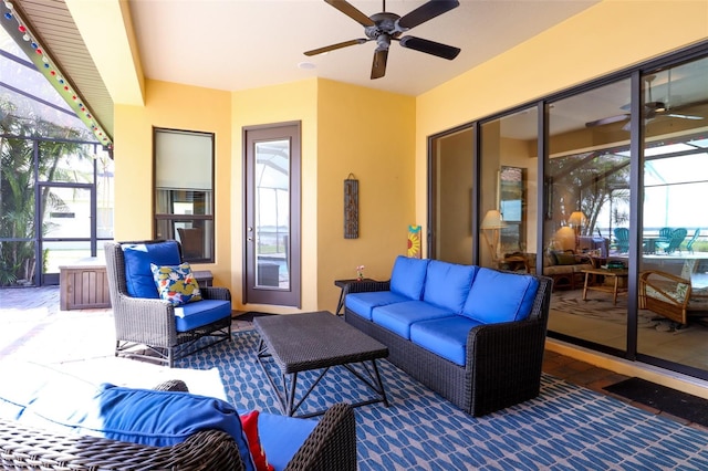 view of patio featuring glass enclosure, ceiling fan, and an outdoor hangout area