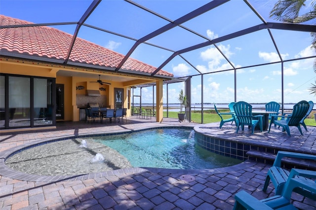 view of swimming pool with glass enclosure, pool water feature, ceiling fan, and a patio