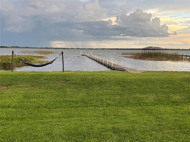 dock area with a water view and a lawn