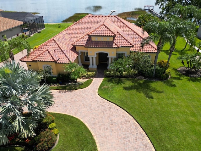 mediterranean / spanish-style house with a front yard, a water view, a tile roof, and stucco siding