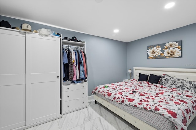 bedroom featuring marble finish floor, a closet, and recessed lighting