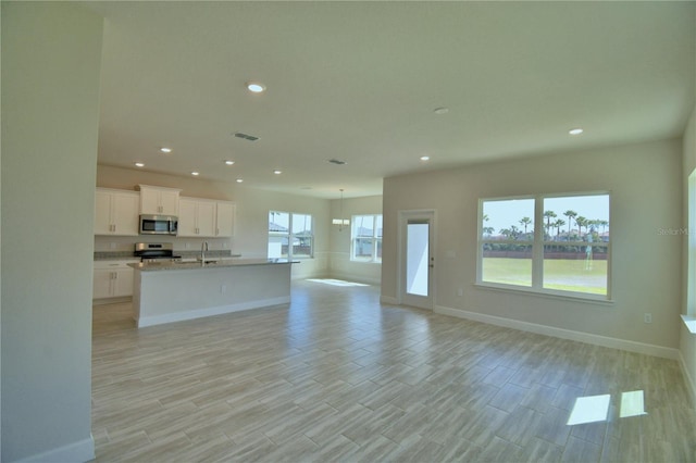kitchen with light countertops, stainless steel appliances, recessed lighting, and open floor plan