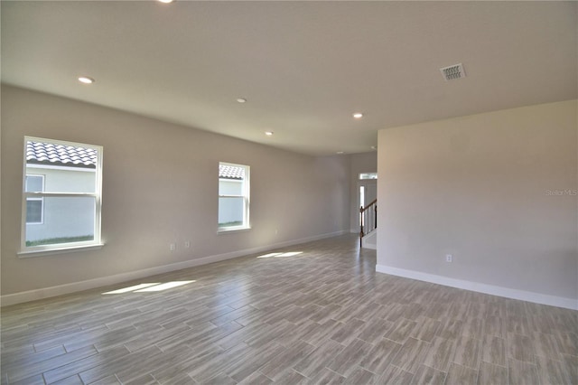 spare room featuring light wood-style flooring, recessed lighting, baseboards, and visible vents