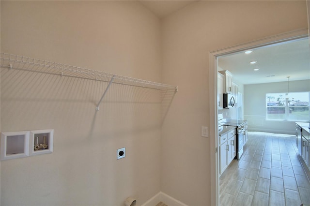 clothes washing area with baseboards, washer hookup, hookup for an electric dryer, and laundry area