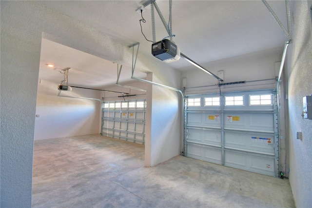 garage with a textured wall and a garage door opener