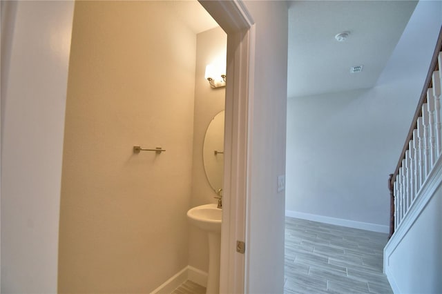 bathroom featuring baseboards, wood tiled floor, and a sink