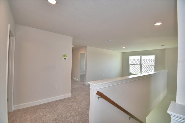 hallway featuring baseboards, an upstairs landing, recessed lighting, and light carpet